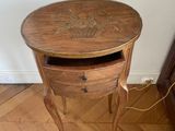 a small wooden table with a drawer on top of it