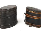 two black leather boxes sitting next to each other on a white surface