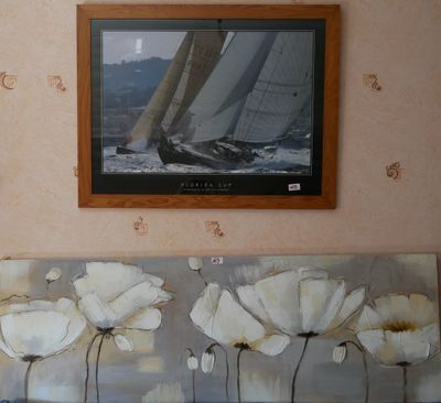 un tableau accroché au mur d'un salon, représentant un voilier