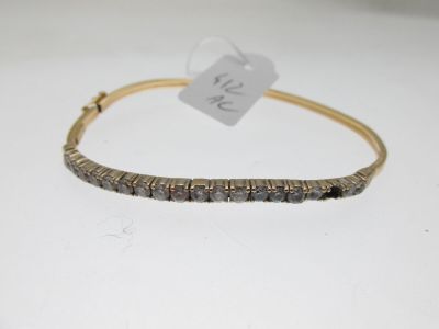 un bracelet en or orné de diamants noirs sur fond blanc