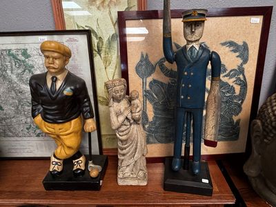 trois figurines posées sur une étagère à côté d'un tableau
