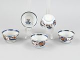 five cups and saucers sitting on a table