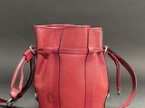 the small red bag is sitting on a gray surface