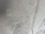 a close up of a white shirt with a flower design on it