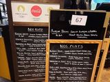 deux panneaux de menu posés au sol dans un café