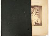 an old black book with a picture of a woman in a nun ' s robe