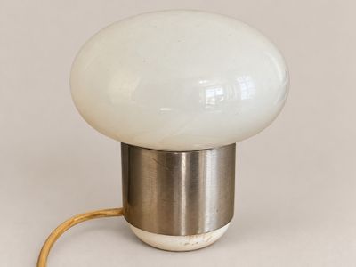 an image of a white lamp with a metal base and a light bulb
