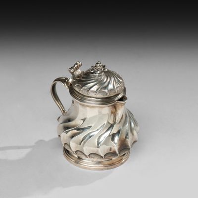 une théière ancienne en métal argenté, avec un couvercle et une anse