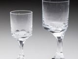 two empty wine glasses sitting next to each other on a table
