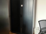 une chaise noire devant une armoire noire et une chaise noire