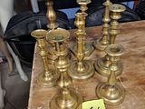 several brass candles are sitting on a wooden table with a price tag