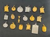 many different types of gold and silver charms on a table