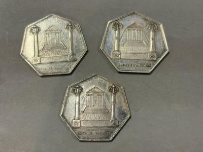 trois pièces d'argent sur lesquelles figure l'image d'un temple