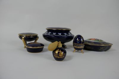 several pieces of blue and gold vases and bowls on a white surface