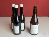 trois bouteilles de vin sont alignées sur un plan de travail
