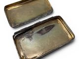 two metal trays sitting on top of each other on a white surface