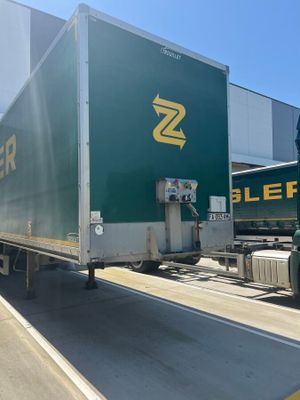 a green semi truck that is parked in front of a building