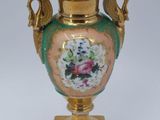 a gold vase with a floral design on it on a stand