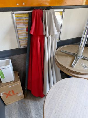 a red robe hanging on the wall next to a table and chairs