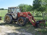 a red tractor that is parked in the grass