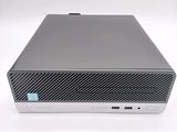 the front view of a silver hp desktop computer sitting on a white surface