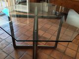 une table en verre avec un plateau en verre posée sur un sol carrelé