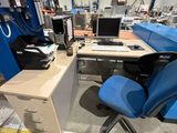 a desk with a computer and a chair in a room