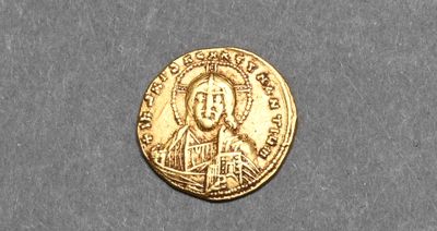 a close up of a gold coin with a picture of a man on it