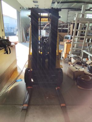 un chariot élévateur dans un entrepôt équipé d'une échelle