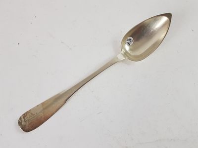 silver spoon with a diamond on it sitting on a white surface