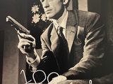 une vieille photo d'un homme en costume tenant un pistolet