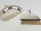 two silver plated brushes and a brush on a white surface