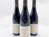 trois bouteilles de vin posées l'une à côté de l'autre sur une table