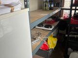 a refrigerator and shelves in a room with a lot of clutter