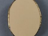an image of a small round mirror sitting on top of a table