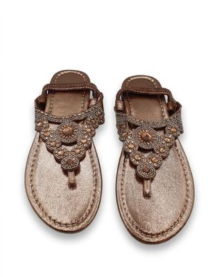 Ces sandales sont en cuir et ornées de perles