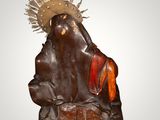 statue of a man with a crown on his head sitting on a rock