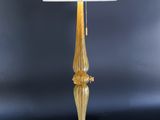 a gold table lamp with a white shade on top of it