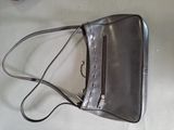 grey leather purse with zippers on top of it sitting on a table