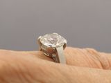 a person holding a diamond ring on their finger