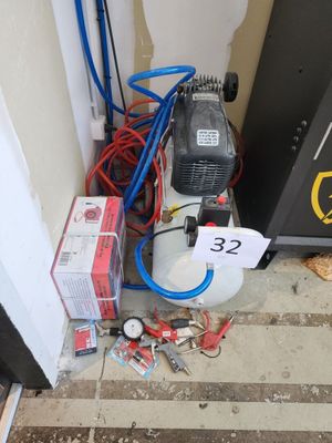 un petit compresseur d'air posé par terre près d'une porte