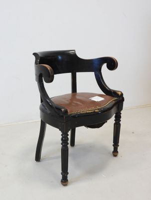 a black chair with a brown leather seat on a white floor