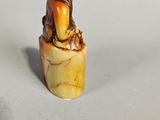 an image of a small figurine of a bird sitting on a piece of wood