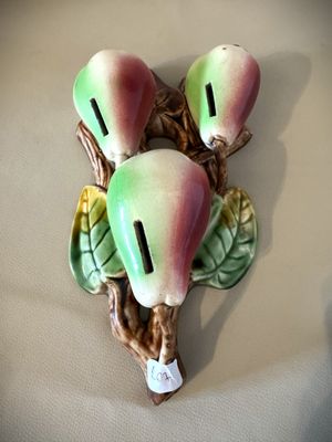 une figurine représentant trois poires sur une branche avec des feuilles