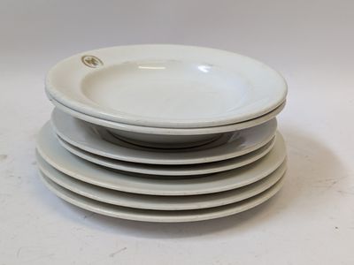 several white plates stacked on top of each other on a table