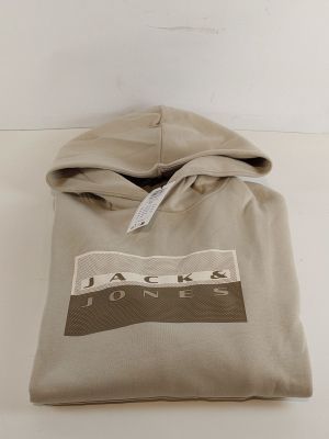 Le sweat à capuche est de couleur beige et arbore un logo noir et blanc.