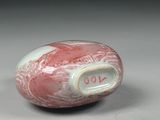 a red and white bead with a number on it