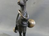 a bronze statue of a deer with a drum and a bell