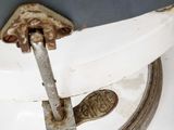a white toilet with a metal handle and a white seat