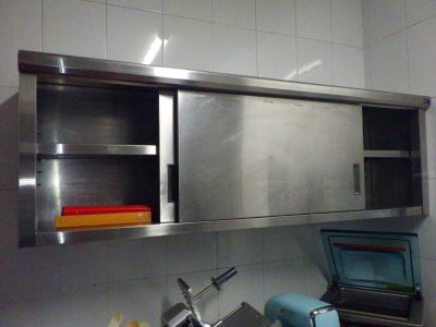 une armoire en acier inoxydable au-dessus d'un évier dans une cuisine